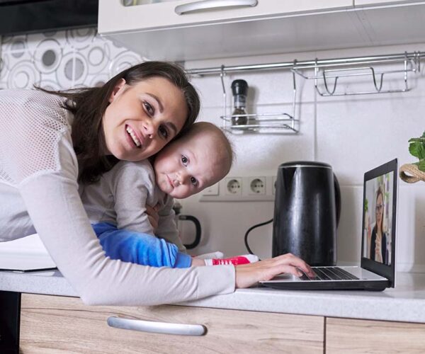 Young mother with toddler in her arms talking online with psychologist Young mother with toddler in her arms talking online with psychologist, making video call, video conference using laptop at home. Technology, mental health, therapy, distance lifestyle concept